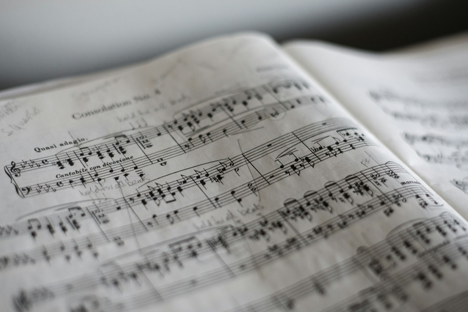 An open score of handwritten classical sheet music under soft light